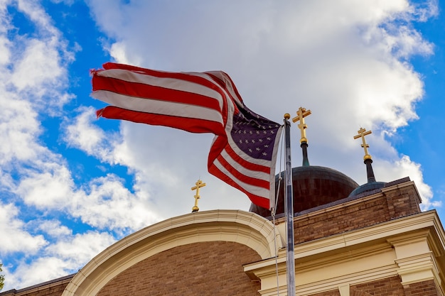 Foto bandiera americana e croce religiosa al tramonto american flag church