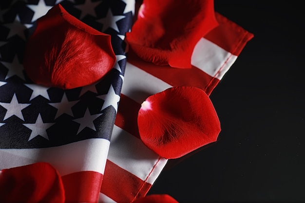 American flag and rose flower on the table. symbol of the\
united states of america and red petals. patriotism and\
memory.