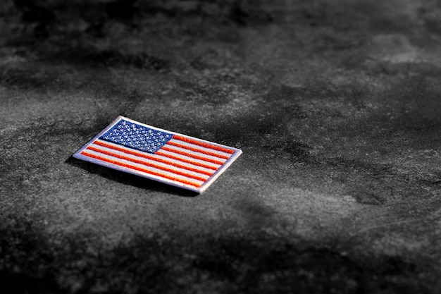 American flag on rusty abandoned metal floor in the dark.