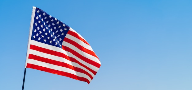 American flag waving in the wind against blue sky