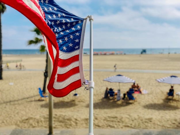 American flag with the beach on the background in Santa Monica beach California USA