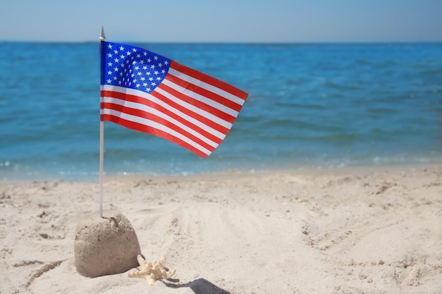 Photo american flag with sand castle on beach