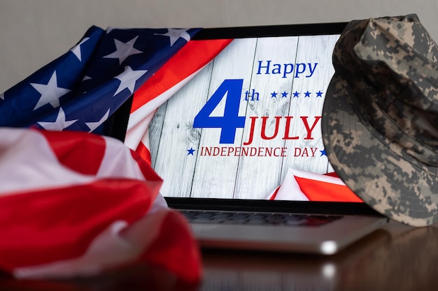 American flags with inscription Happy Independence Day on laptop