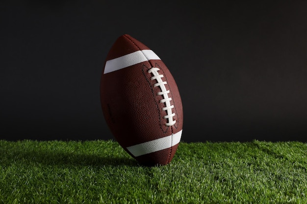 American football ball on black background american football on\
green grass