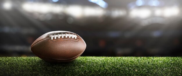 Photo american football ball on the grass of a stadium