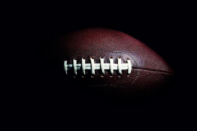 American football ball isolated on black space