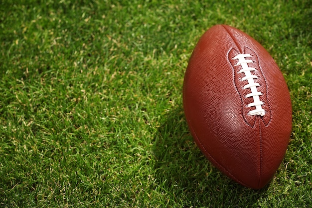 Фото Мяч для американского футбола на зеленой траве