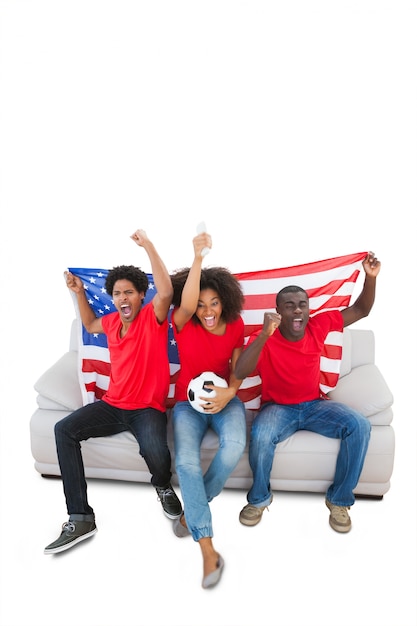 American football fans in red cheering on the sofa