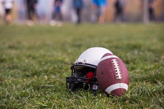 American football helm en bal liggend op het veld