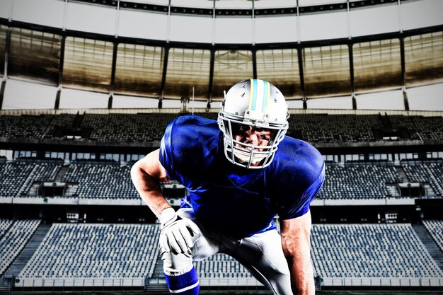 American football player against rugby goal post in a stadium\
front view of rugby goal post in a empty stadium