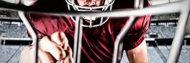 American football player against rugby goal post in a stadium\
front view of rugby goal post in a empty stadium