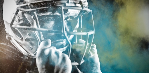 Foto giocatore di football americano contro gli schizzi di polvere colorata