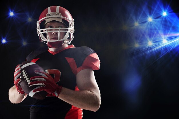 American football player in helmet holding rugby ball