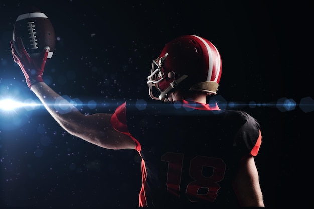 American football player in helmet holding rugby ball