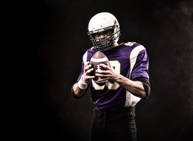 American football player holding the ball in his hands