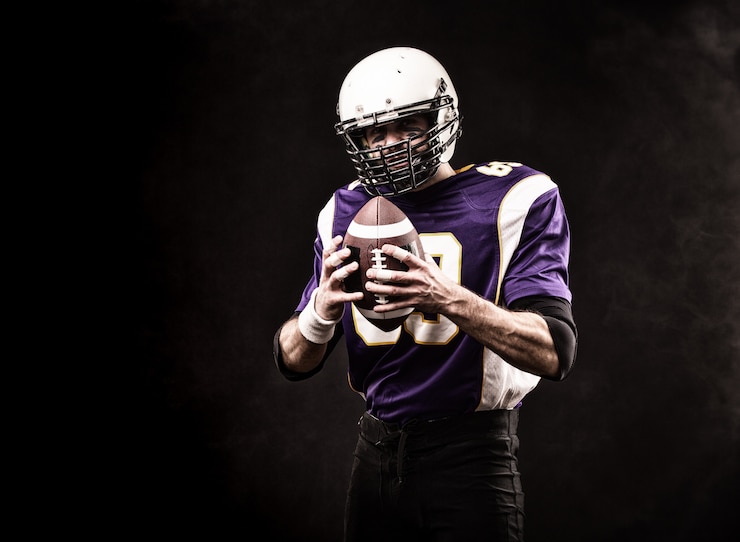 Photo american football player holding the ball in his hands