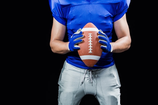 Photo american football player holding ball