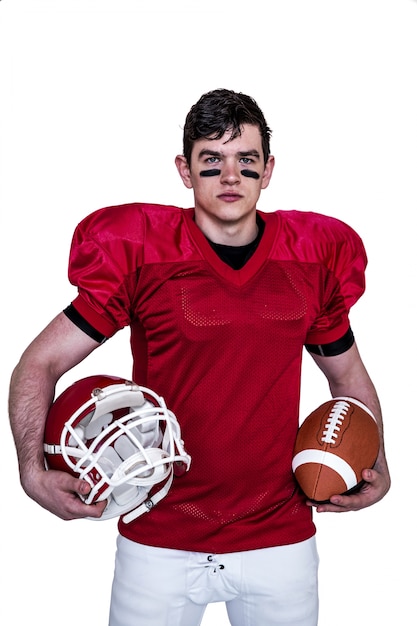 American football player holding helmet and a ball