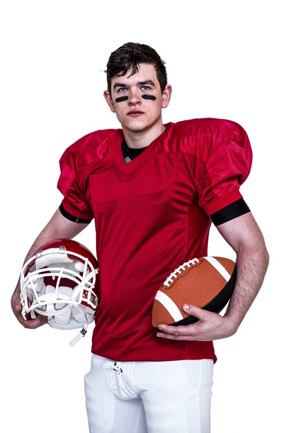 American football player holding helmet and a ball