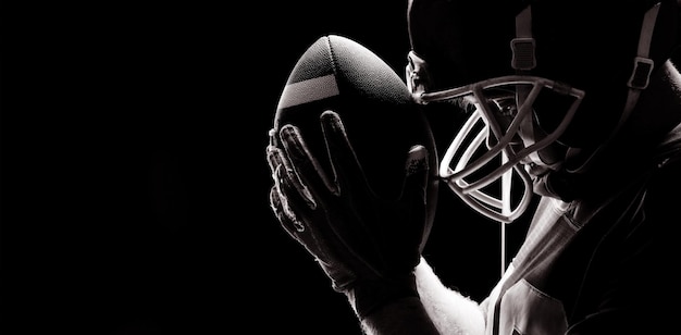 Photo american football player standing with rugby helmet and ball