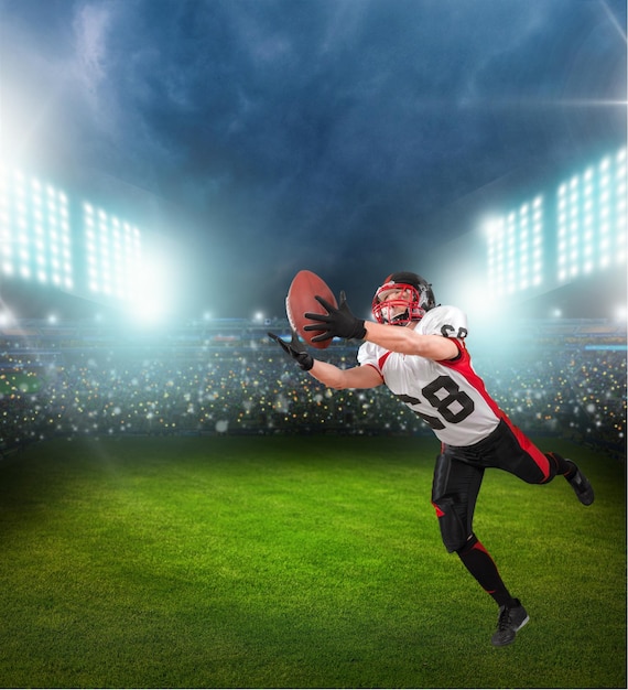 American football player with the ball on stadium background