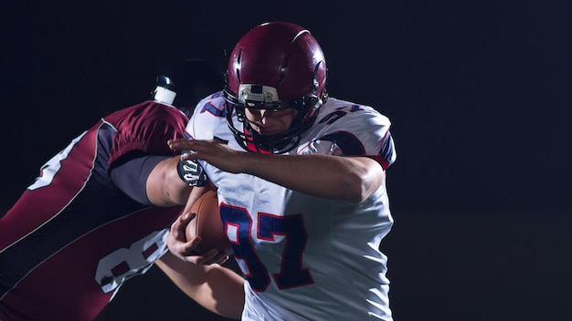 American football players in action at night game time on the field