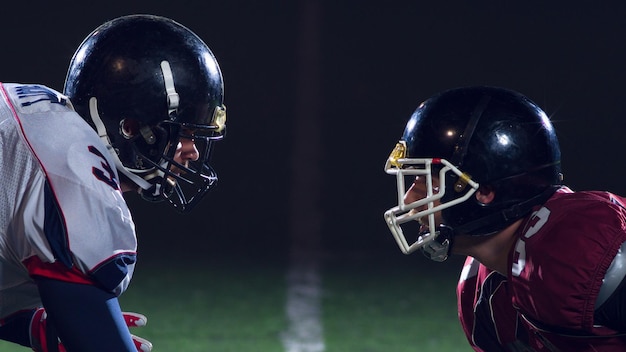 american football players are ready to start on field at night