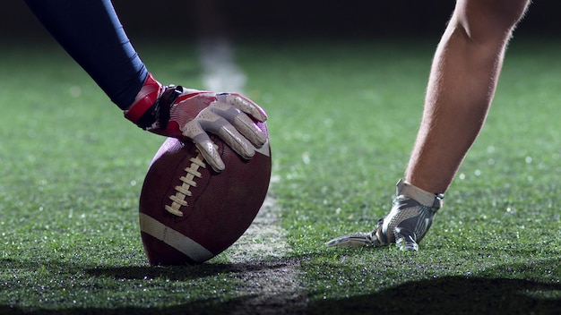 american football players are ready to start on field at night