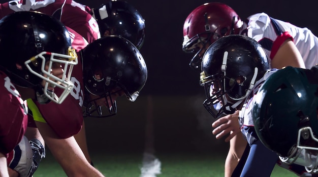 american football players are ready to start on field at night