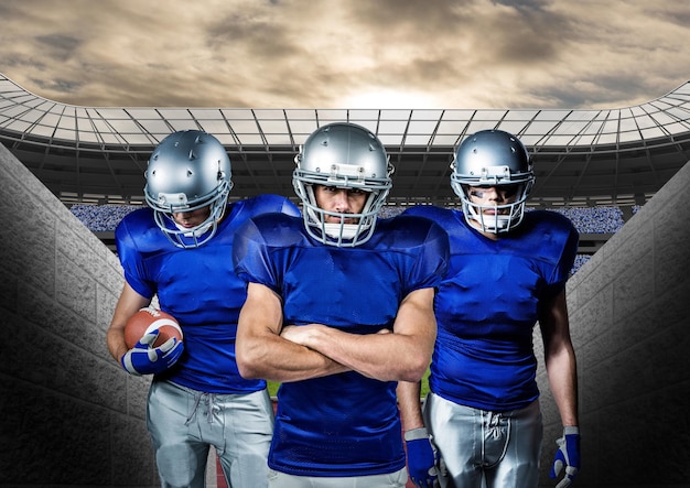 american football players standing against stadium in background