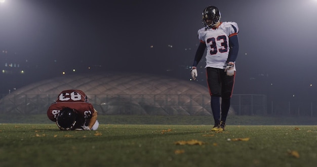 American football-spelers in actie 's nachts op het veld