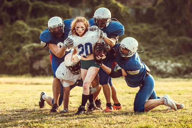 Giocatore della donna di football americano nell'azione sullo stadio