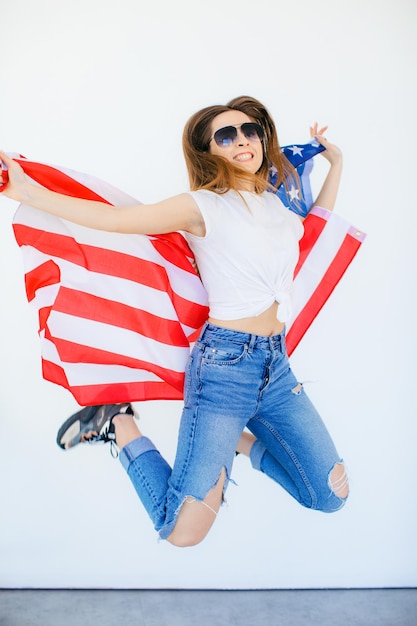 American girl Happy young woman in heart shape sunglasses on USA flag on white background