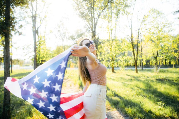 アメリカの女の子アメリカの国旗を持つ幸せな若い女性