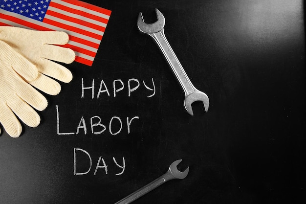 Photo american holidays concept happy labor day with wrench and gloves on blackboard