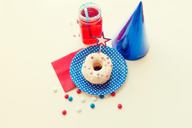 american independence day, celebration, patriotism and holidays concept - close up of glazed sweet donut decorated with star, juice in glass mason jar or mug and candies at 4th july party from top