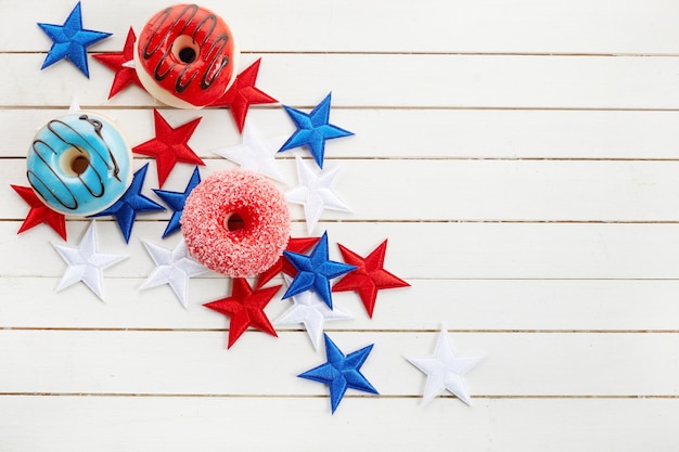 American independence day holidays concept Donut in disposable tableware and stars at 4th july party on wooden background