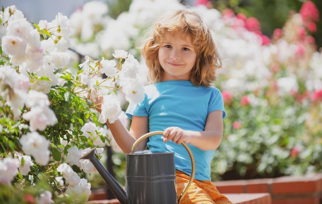 American kids childhood. Child watering flowers in garden. Home gardening.