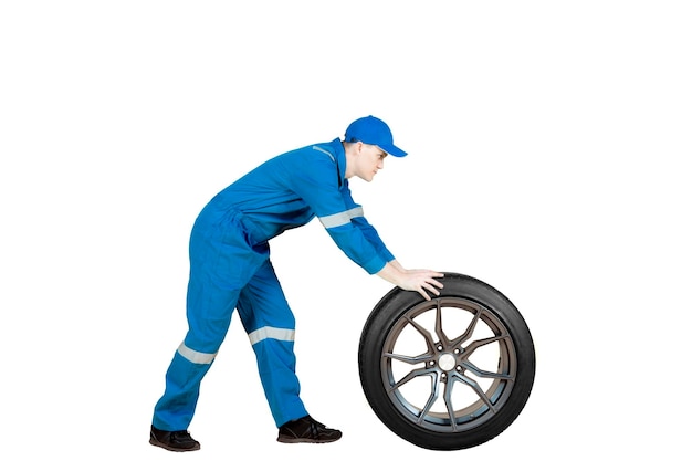 スタジオで車のホイールを押しているアメリカ人メカニック