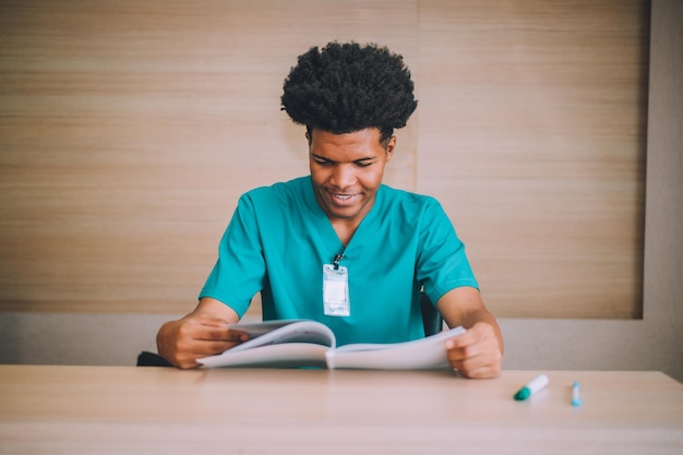 American medical student is reading a book to prepare for an exam in a hospital