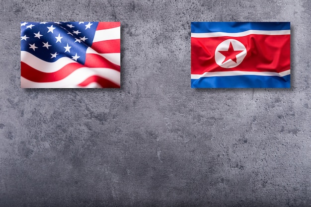 American and North korea flags. Usa and North korea flag on concrete background.