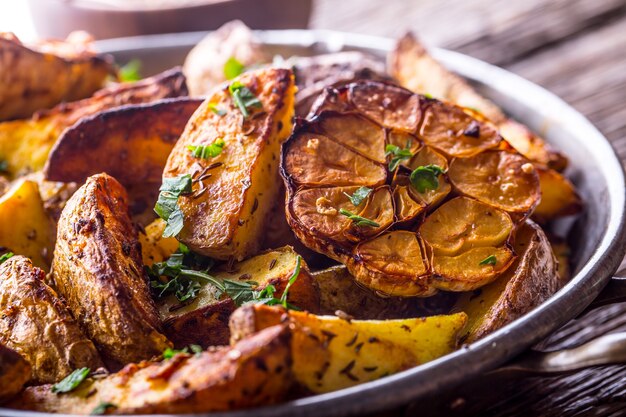 Foto patate americane. patate al forno con la buccia. patate arrosto con aglio spezie sale cumino ed erbe aromatiche.