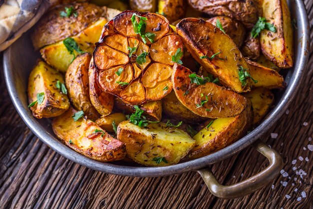 American potatoes. Baked potatoes in peel. Roasted potatoes with garlic spices salt cumin and herbs.