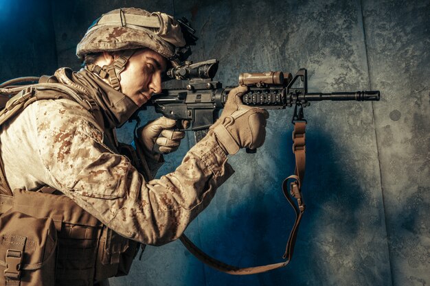 American private military contractor shooting a rifle. Studio shot