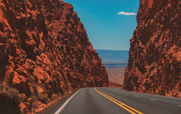 高い岩に対するアメリカのロードトリップ道路