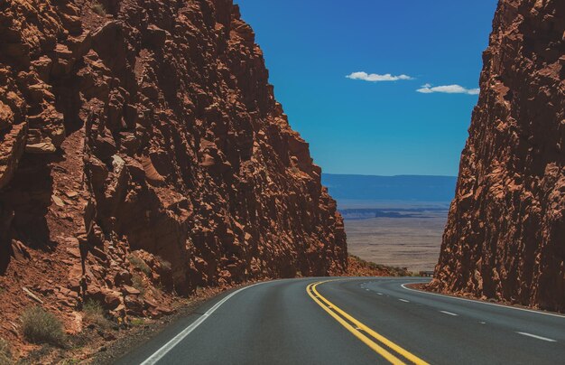 夏のフィールド間のアメリカのロードトリップ田舎のアスファルト道路