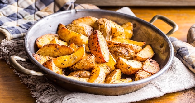 Foto patate americane arrosto con pancetta affumicata aglio sale pepe cumino aneto prezzemolo decorazione alle erbe