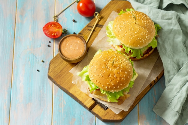 Spuntino americano cibo di strada fast food hamburger fatti in casa su tavola rustica in legno