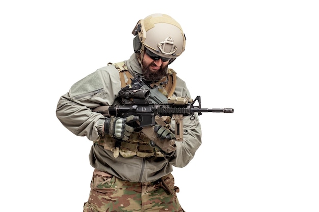 American soldier in military equipment with a rifle on a white background reloads weapons