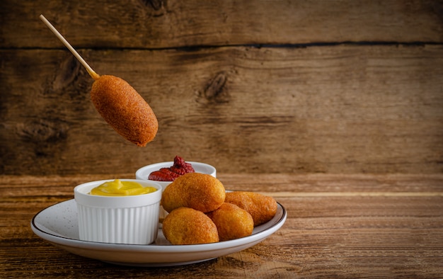 American street food concept. Corn dogs with mustard  with copy space